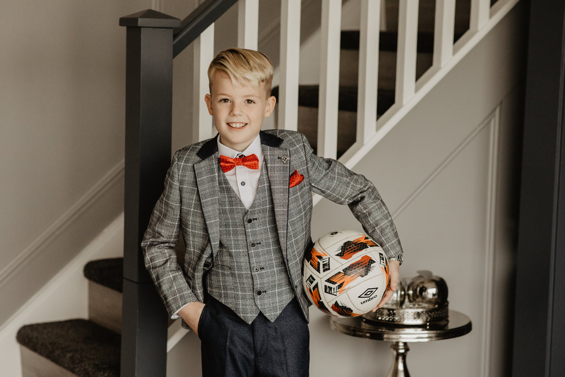 Communion day for a boy. He has his favourite ball. Communion Photographer in Ireland